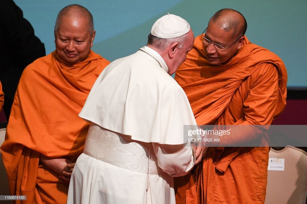 Pope Francis (C) shakes hands with a Buddhist monk as he meets with leaders of Christian denominations and other religions at Chulalongkorn Univeristy in Bangkok on November 22, 2019. (Photo by Mohd RASFAN / AFP) (Photo by MOHD RASFAN/AFP via Getty Images)